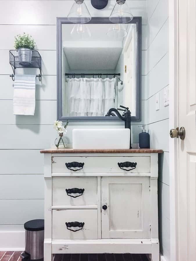 Custom distressed vanity and farmhouse decor in a modern rustic bathroom room makeover.